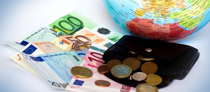 Billets de banque en Euro à coté d'u portefeuille et d'un globe montrant l'Europe (France)