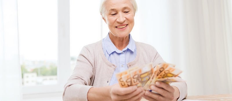 Une femme âgée en train de compter des billets euros