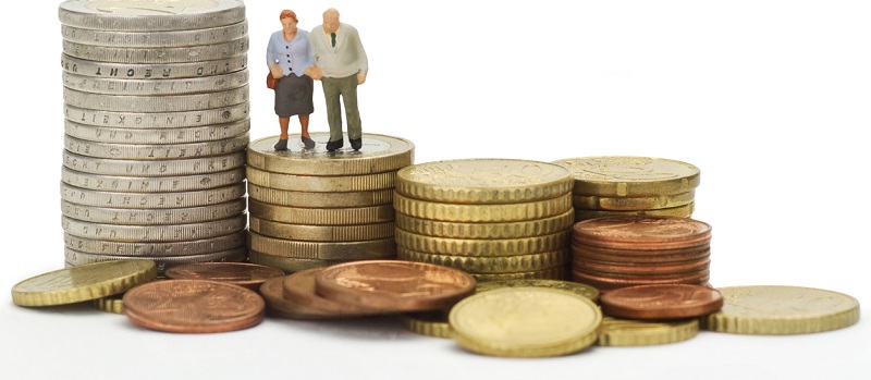 Deux personnes âgées en miniature placées avec des pièces de monnaies