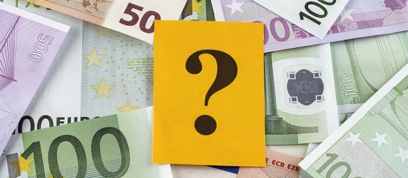 Un carton jaune avec un point d’interrogation sur des billets de banque