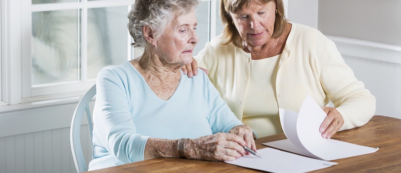 une femme âgée devant une souscription d'assurance vie