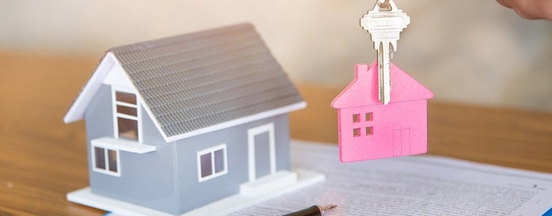 Agent immobilier tenant la clé de la maison à son client après la signature d'un accord de contrat en bureau, concept immobilier, location de propriété.