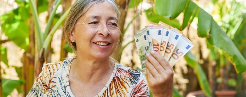 Une femme tenant des billets de 50 euros
