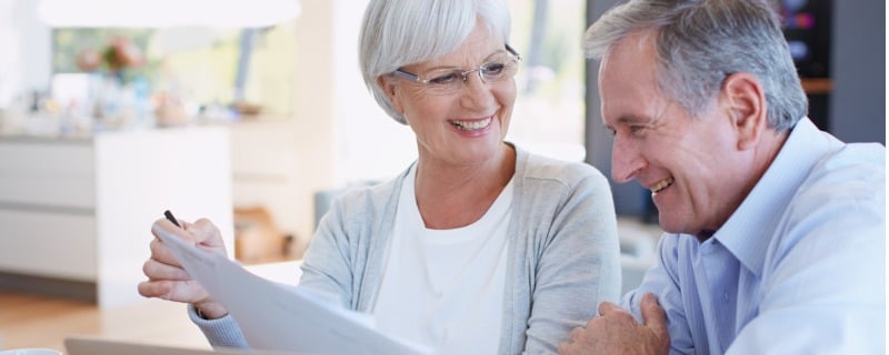 Plan d’un couple de personnes âgées travaillant sur leurs finances en utilisant un ordinateur portable