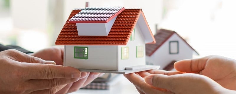 Les agents immobiliers travaillent dans le bureau avec la paperasse et offrent un plan de maison pour que les clients achètent et achètent avec l’assurance.