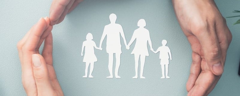 Concept de soins familiaux. Mains avec silhouette en papier sur une table. 