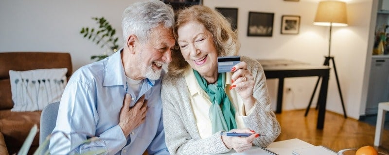 Les hommes et les femmes âgés utilisent un ordinateur portable à la maison pour planifier leur budget.