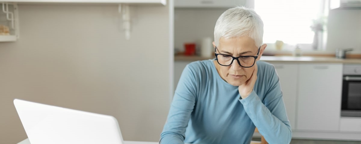 Femme âgée effectuant des travaux bancaires et administratifs à domicile, concept de retraite.