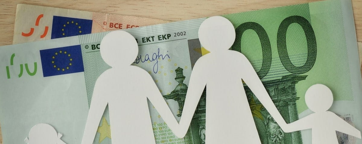 Découpe d'une famille en papier sur des billets de banque en euros - Concept de budget familial.