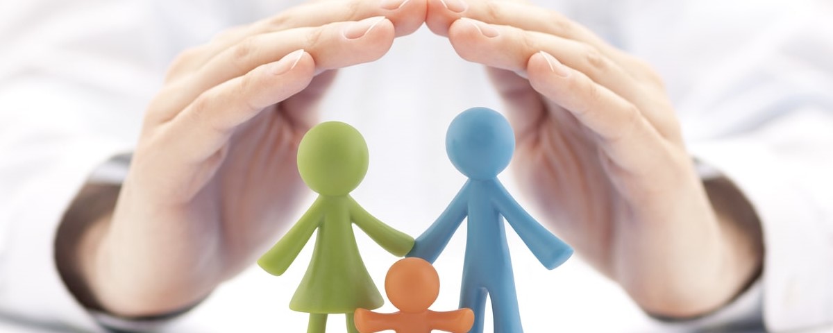 Concept d'assurance familiale avec des figurines de famille colorées couvertes par des mains 