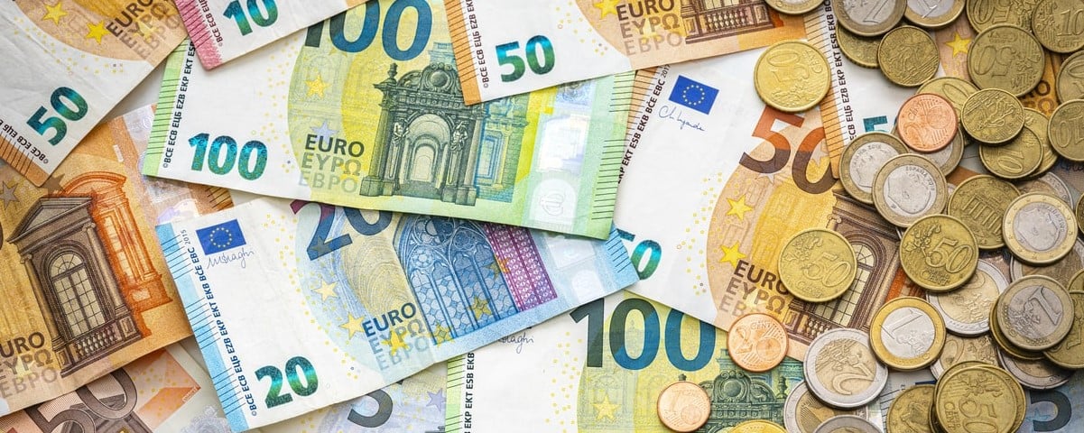 Vue aérienne de billets de banque et de pièces en euros.
