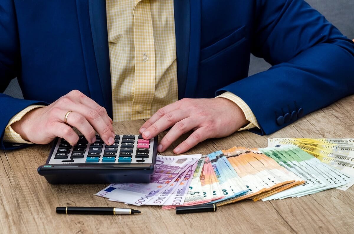 L'homme d'affaires compte les euros à l'aide d'une calculatrice