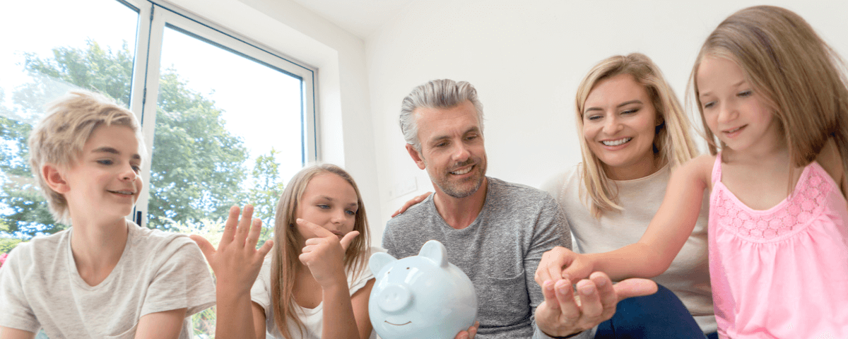 Portrait d'une famille caucasienne heureuse économisant de l'argent dans une tirelire - concepts de finances domestiques
