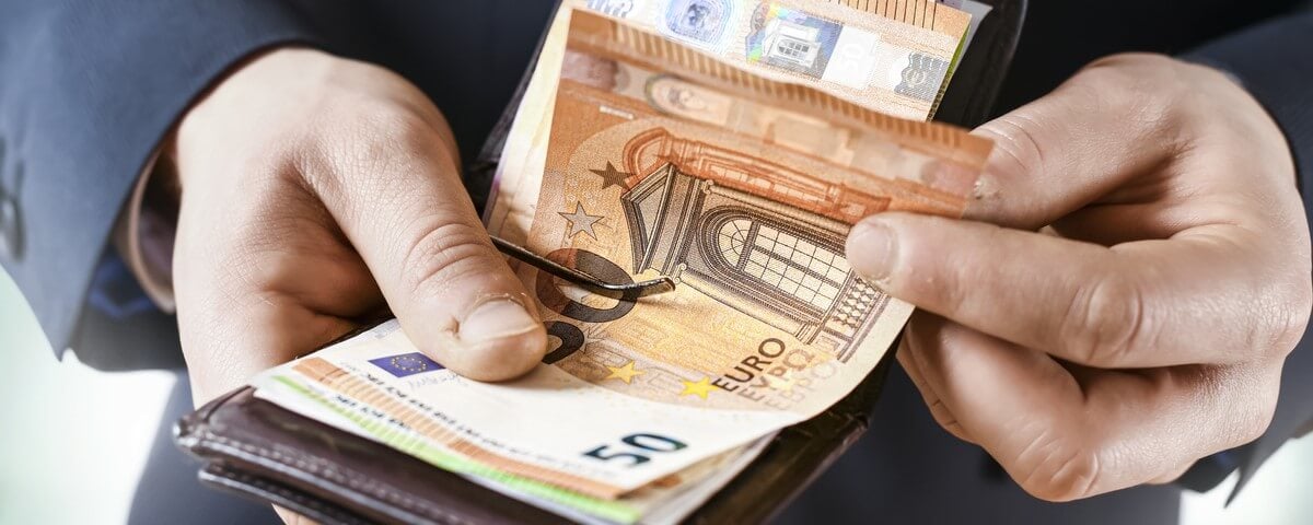 Détail des mains de l'euro-monnaie en papier.
