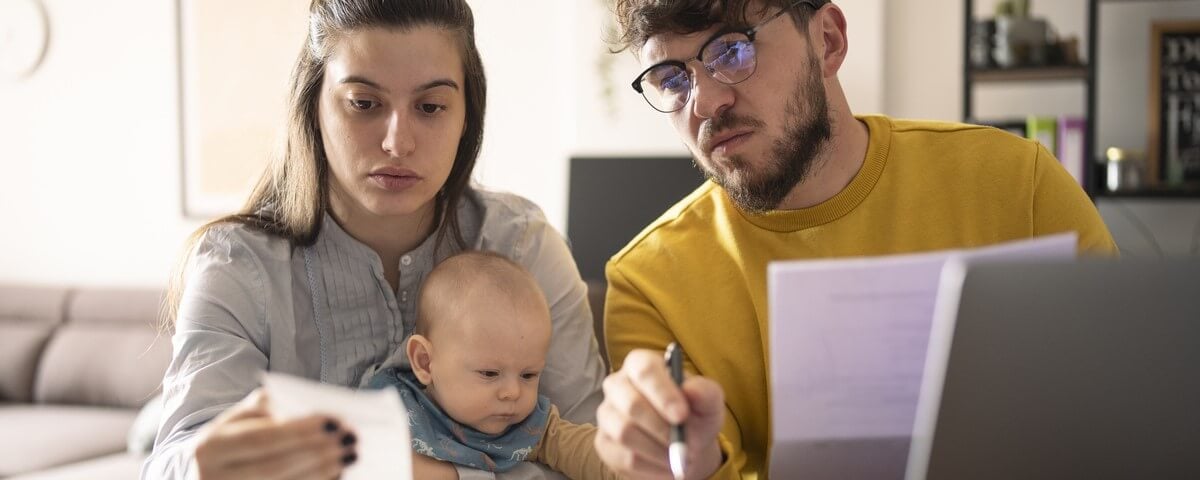Une jeune famille avec un bébé en bas âge calcule ses dépenses mensuelles.
