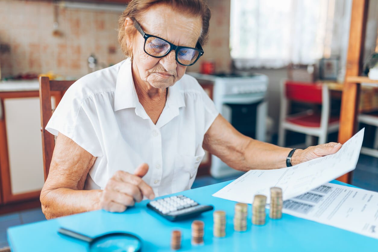 Femme âgée à domicile vérifiant ses finances et ses investissements.