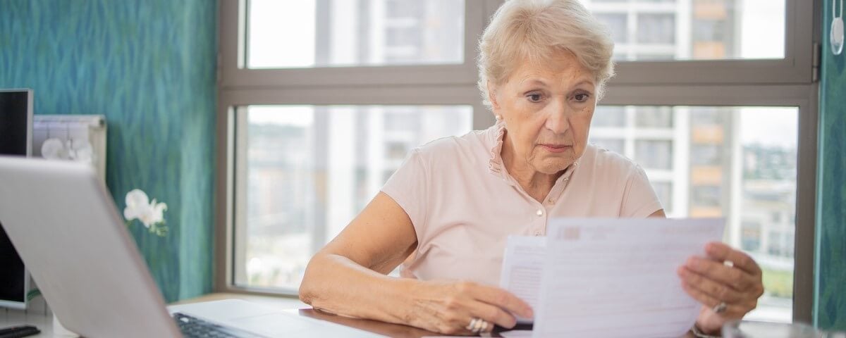 Une vieille femme examinant son rapport de retraite.