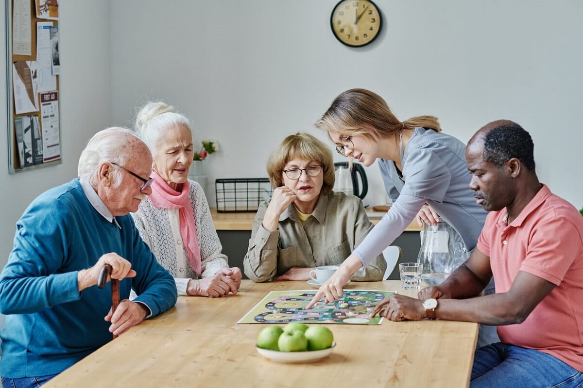 L’aidant explique la règle du jeu aux personnes âgées