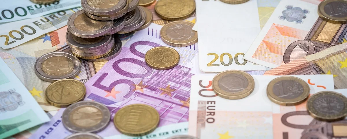 pièce d'euro posée sur des billets de banque gros plan