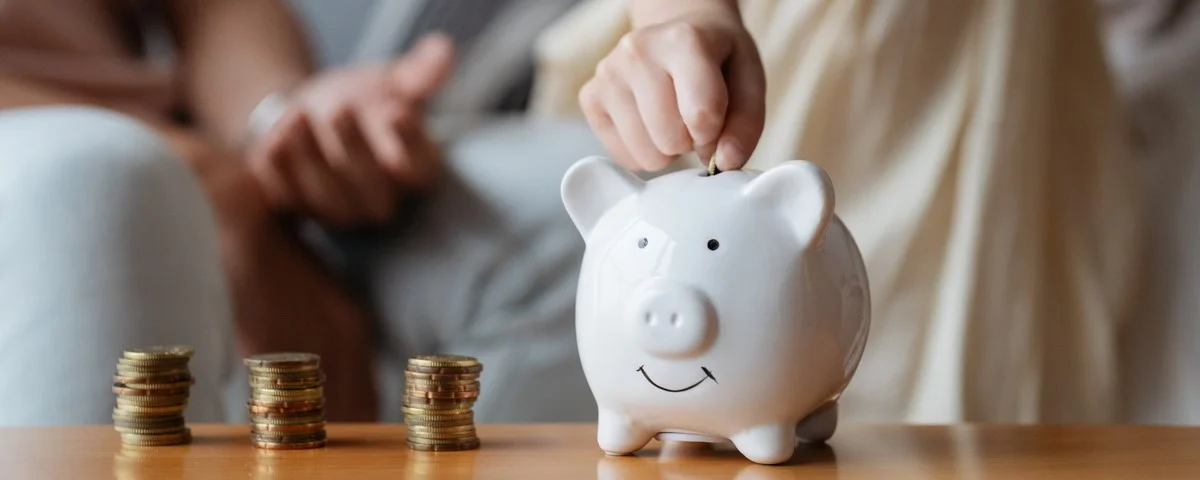 Concept de l'enfant qui économise de l'argent. Une petite fille met des pièces de monnaie dans une tirelire pour épargner. 