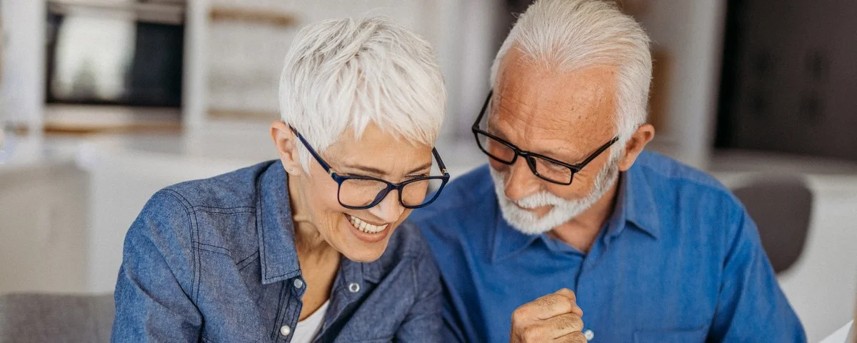 Portrait d'un couple de seniors gérant leurs finances à domicile.