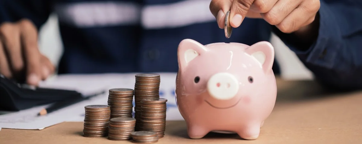 Homme mettant une pièce d'argent dans une tirelire pour épargner de l'argent, de la richesse et un concept financier.