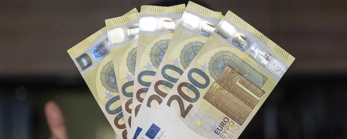 Un homme d'affaires compte les billets de banque. Un homme lui remet 1000 dollars.