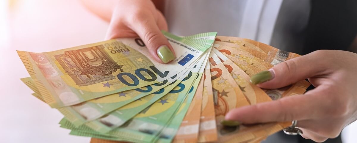 Main d’une femme d’affaires tient des billets en euros.