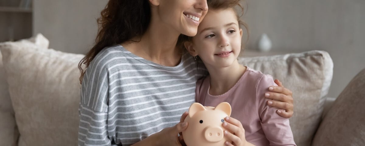 Maman et sa fille souriantes s’occupent des finances familiales.