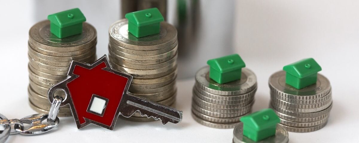 Modèles de maisons, pièces de monnaie, porte-clés en forme de maison rouge et tirelire. Accumuler pour devenir propriétaire et budget familial. 