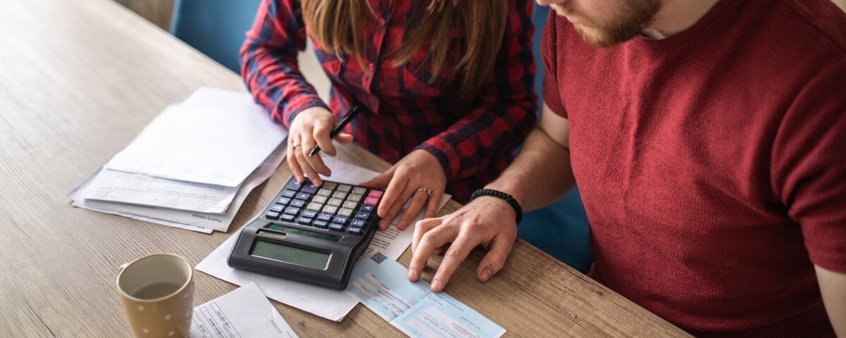 Jeune couple pacsé payant ses factures en ligne et gérant les finances de la maison à l'aide d'un ordinateur portable à la maison.