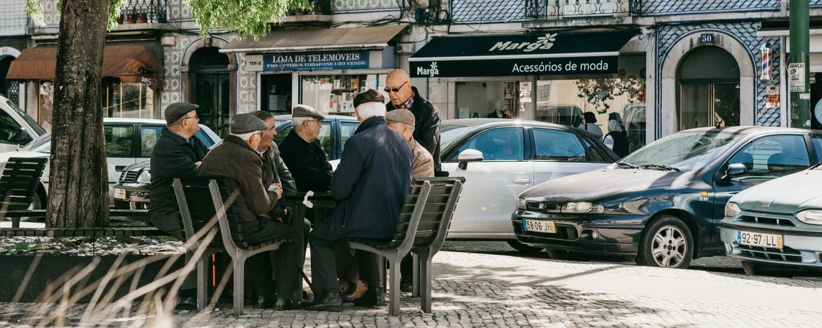 Habitants de hommes âgés assis sur un banc et communiquent à Lisbonne au Portugal