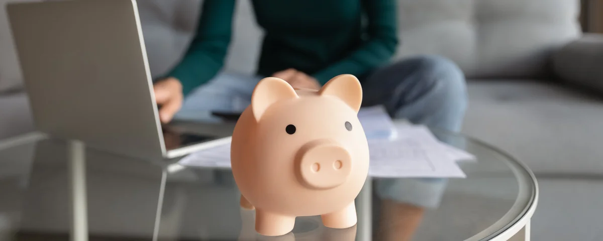 Jeune femme gérant le budget du ménage au bureau à domicile à l’aide d’un ordinateur portable.