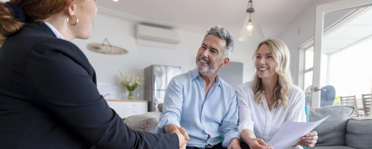 Heureux couple d'âge mûr rencontrant un conseiller en investissements et en finances à la maison. 