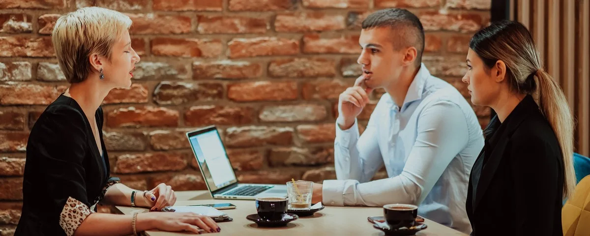 Jeune couple concluant de contrat avec un agent financier au bureau. 