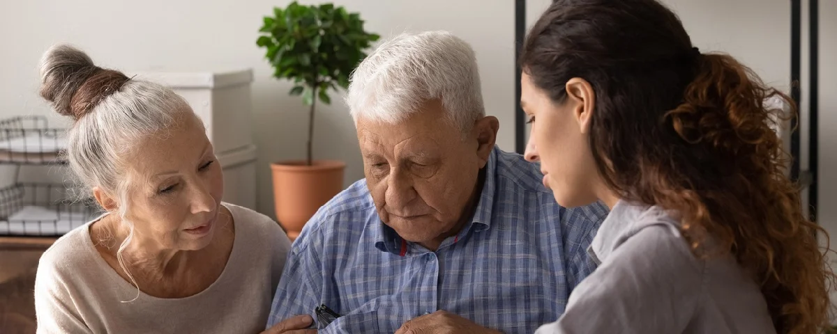 Une agent d’assurance conseillant un couple d'âge mûr concluant un contrat d'assurance ou d'investissement.