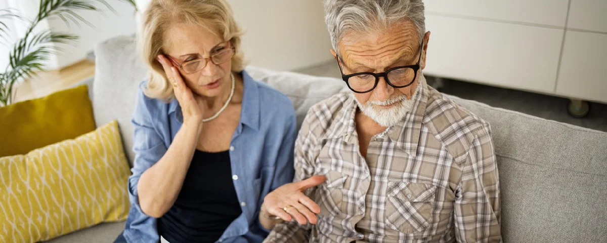 Photo d'un couple âgé semblant stressé alors qu'il examine ses finances à la maison.