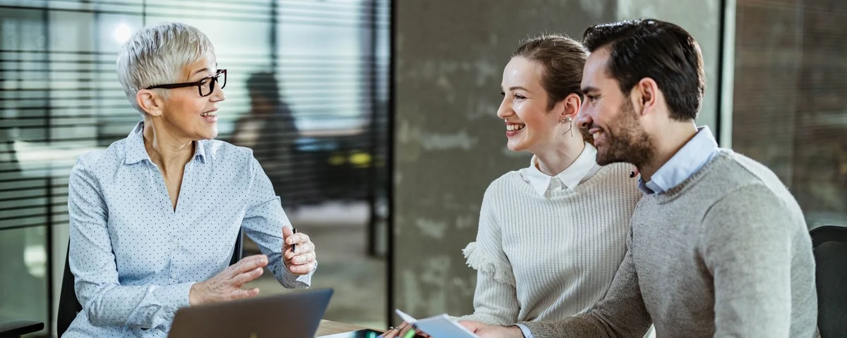 Couple heureux communiquant avec leur agent dans le bureau.