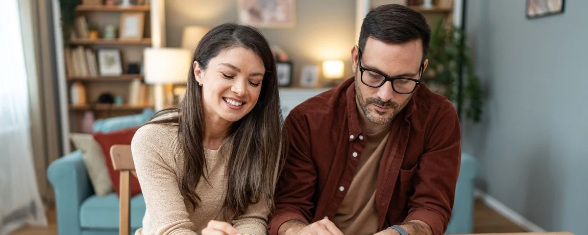 Jeune couple heureux économisant de l'argent pour leur prochain investissement.