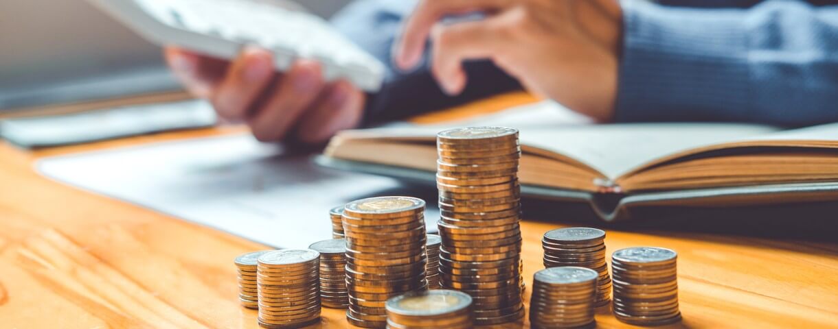 Concept d'épargne : main d'homme déposant une rangée de pièces de monnaie