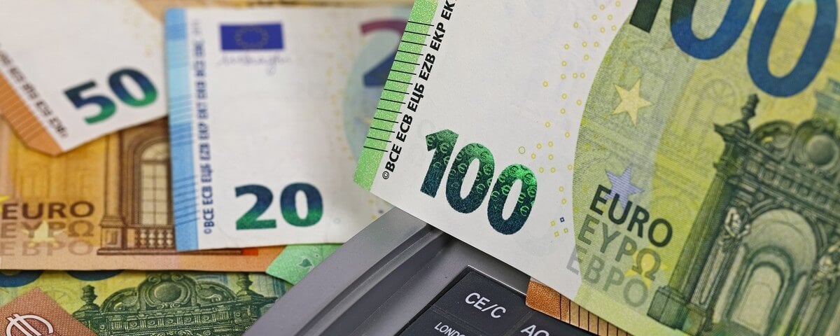 Des billets de banque de l’Union européenne entre lesquels on aperçoit partiellement une calculatrice. Cette image peut servir à illustrer un large éventail de sujets liés aux finances.