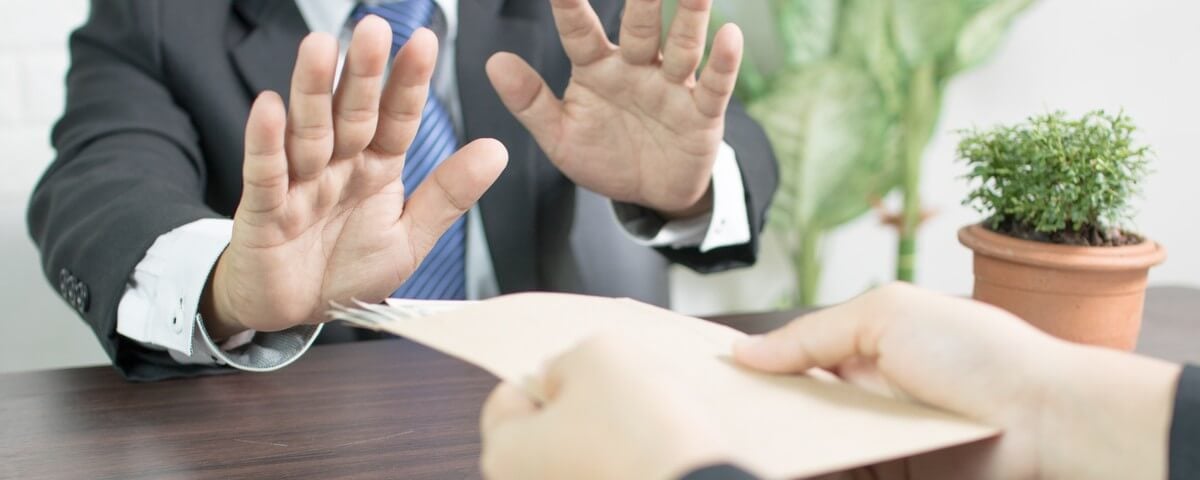 un homme d'affaires qui refuse une tentative de corruption en faisant un clin d'œil et cesse d'accepter de l'argent au bureau